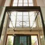 Im Zusammenspiel mit den Glasfenstern im gotischen Stil und den Türen mit Kupferpaneel bildet der moderne Windfang eine überzeugende optische Einheit.
